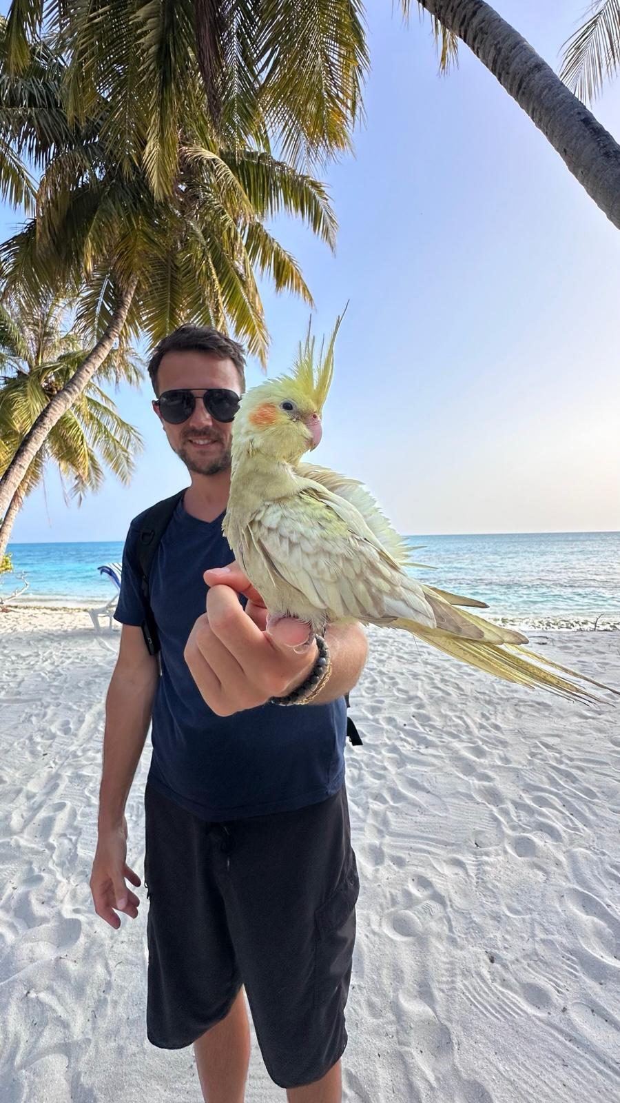 Marco mit einem Nymphensittich am Strand